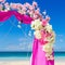 Wedding on the beach . Wedding arch in purple decorated with flo
