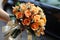 Wedding bliss Bride displays a bright bouquet of orange roses