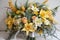 A wedding bouquet with daffodils, air plants, ferns and other yellow, white and peach flowers