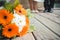 Wedding bouquet of daisies and gerberas in the foreground, the feet of the bride and groom in the background