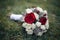 Wedding bouquet of freshly cut flowers, roses and peonies on grass closeup