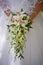 Wedding bouquet in hands of bride orchids, form hanging. Floral