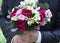 Wedding bouquet in hands at the groom. Flowers close-up