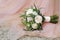 A wedding bouquet lies on the bride`s dress. Bridal bouquet