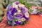 Wedding bouquet on an orange pillow, bouquet of bride from rose cream spray, rose bush, rose purple Memory Lane, violet eustoma, e
