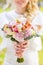 Wedding bouquet of pale pink and white roses in hands of bride