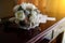 Wedding bouquet of peonies and roses lying on a wooden vintage table near wedding rings on the background of the invitation in the