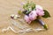 Wedding bouquet of pink, violet and blue flowers and ribbons, boutonniere and pearl barrette