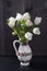 Wedding bouquet of tulips with Ruscus in a jug on a black background