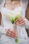 Wedding bouquet of white calla lilly flowers in hands of young bride