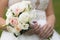Wedding bouquet of white and pale pink rose in hands of bride