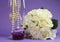 Wedding bouquet of white roses with purple cupcake and pearls in champagne glass
