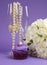 Wedding bouquet of white roses with purple cupcake and pearls in champagne glass - vertical.
