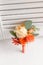 Wedding boutonniere of orange roses to the man to the groom. white background.