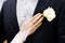 Wedding boutonniere on suit of groom and brides hand