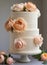 Wedding cake with barely there icing decorated with peach colored peony flowers