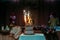 Wedding cake with burning sparklers in a darkened festive hall. Large cake decorated with figures of bride and groom. Culmination