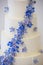 Wedding cake detail with white frosting and small blue flowers - wedding cake series