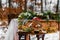 Wedding cake with fruit and an old wooden table with needles of cones and leaves during a wedding ceremony in winter on snow in