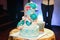 Wedding cake with three tiers of white blue glaze decorated with flowers and hearts