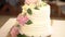 Wedding cake with white cream, decorated with flowers of peonies and lisianthus