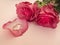 Wedding celebration with pink rose bouquet, gold wedding rings isolated on pink background. Concept of love and romance