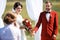 The wedding ceremony, bride and groom give oaths listen to speaker. Sunny summer day. color style decoration red marsala