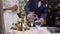 A wedding ceremony with a mixed family. The groom, mother, and son perform a unity sand ceremony mixing each of their