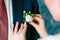 Wedding . Close up bride`s hands pinning boutonniere to groom` jacket