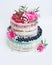 Wedding color drip cake with roses, blueberries and raspberries