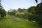 Wedding couple - bride and groom - seating on green grass on hill