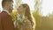 Wedding couple caresses and kisses each other among sun blinks in wild steppe