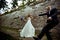 A wedding couple dance behind a stone wall