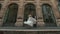 Wedding couple dances on old european city street in front of large vintage showcases