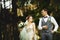 A wedding couple enjoys walking in the woods. Newlyweds hug and hold hands