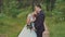 Wedding couple in the forest. The bride laid her head on the groom`s shoulder. A touching moment for a wedding day