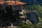 Wedding couple holding hands on a rock at Meteora- landscape