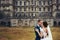 Wedding couple hugs standing on the bakcyard of an old ruined ca