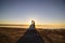 Wedding couple kissing on the sea beach watching sunset. Sunny summer photo. Bride with hair down in off shoulder dress with train