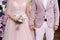 Wedding couple. Lilac, violet, purple, pink marriage concept. Bride and groom holding hands at outdoor wedding ceremony