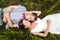 Wedding couple in love lying in green grass in summer meadow