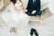 Wedding couple sitting on the sofa barefoot. Bride and groom holding hands together. Love story. Elegant clothes. Cosy home