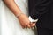 Wedding couple standing and holding hands. Closeup bride`s jewelry bracelet on wrist. Wedding day concept.