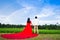 wedding couple standing under rainbow curve blue sky