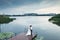 Wedding couple stands on the berth of river with an industrial b