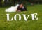 Wedding couple unfocused and love word on the grass