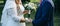 Wedding couple walking in the green park. Curvy bride in white lace dress and groom are holding hands. Overweight happy people.