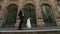 Wedding couple walks on old european city street in front of large vintage showcases