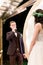 Wedding day. Attractive stylish groom in suit saying an oath, while looking at the bride in elegant rustic dress and