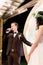 Wedding day. Attractive stylish groom in suit saying an oath, to his bride in elegant rustic dress and wreath on head